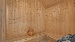 A wooden sauna room with benches and a wooden bucket. - Beautiful home in Væggerløse with WiFi (Væggerløse)