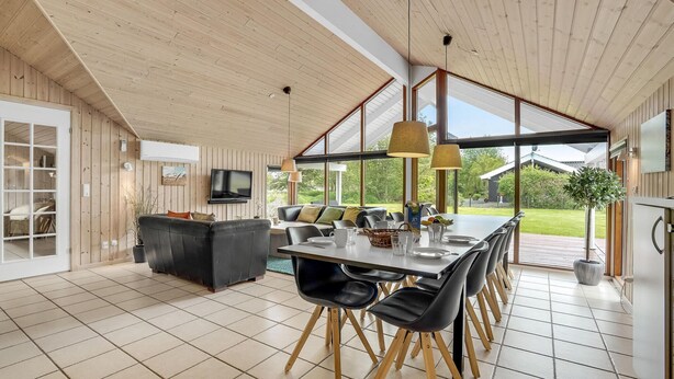 A spacious dining area with a long table, black chairs, and a television mounted on the wall. - Beautiful home in Væggerløse with WiFi (Væggerløse)