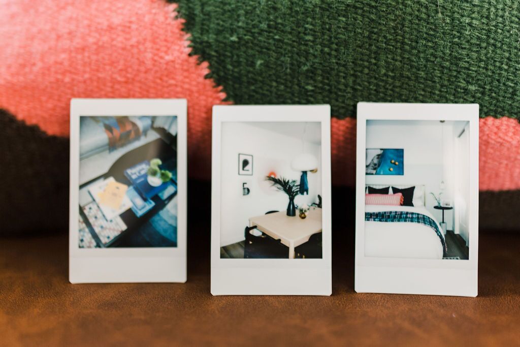 Tre foto Polaroid di ambienti diversi: una cucina, una sala da pranzo e una camera da letto.