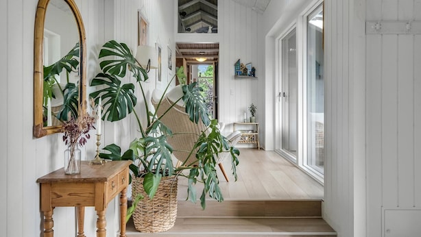 A hallway with a wooden table, a large mirror, and various potted plants. - Lovely home in Odder with kitchen (Odder)