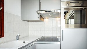 Een moderne keuken met roestvrijstalen apparatuur, een inbouwoven en een spoelbak met kraan.