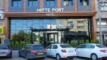 Experience the sleek, modern exterior of Mittte Port Hotel, featuring a glass facade that reflects the surroundings.