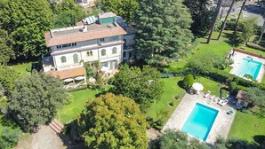 Une vaste villa à plusieurs étages, dotée d’une piscine et de jardins luxuriants.
