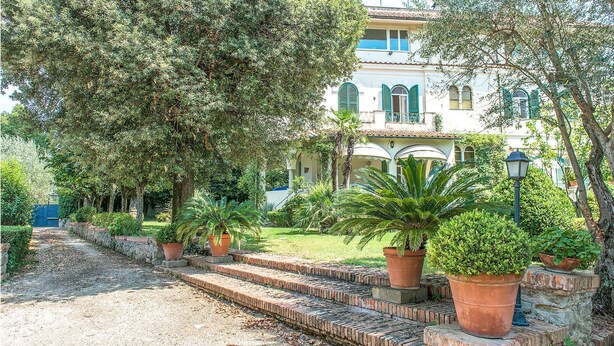 Un bâtiment doté d’un jardin et d’un chemin qui mène à un escalier.
