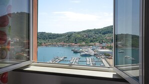 A marina with boats docked, a hilly landscape in the background, and a clear sky. - Amazing apartment in Portovenere (Portovenere)