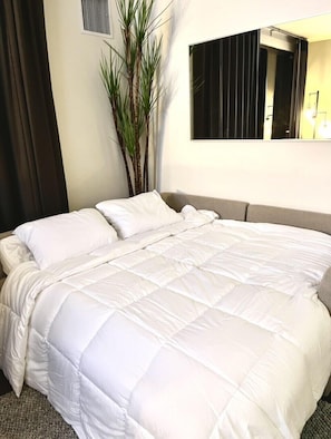 Un lit bien fait, avec du linge de lit blanc, dans une chambre d'hôtel.