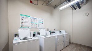 A laundry facility with multiple washing machines, a wall-mounted instruction poster, and a tiled floor. - Amazing Views & Pool - Lake Las Vegas Retreat  (Henderson)