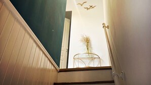 A staircase with a wooden ceiling and walls painted in teal and white.