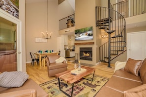 Relax in this stylish living area with a comfortable sofa, fireplace, and dining space.