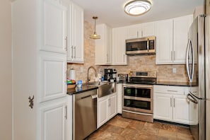 Enjoy cooking and dining in this well-lit kitchen with a dishwasher, microwave, oven, and refrigerator.
