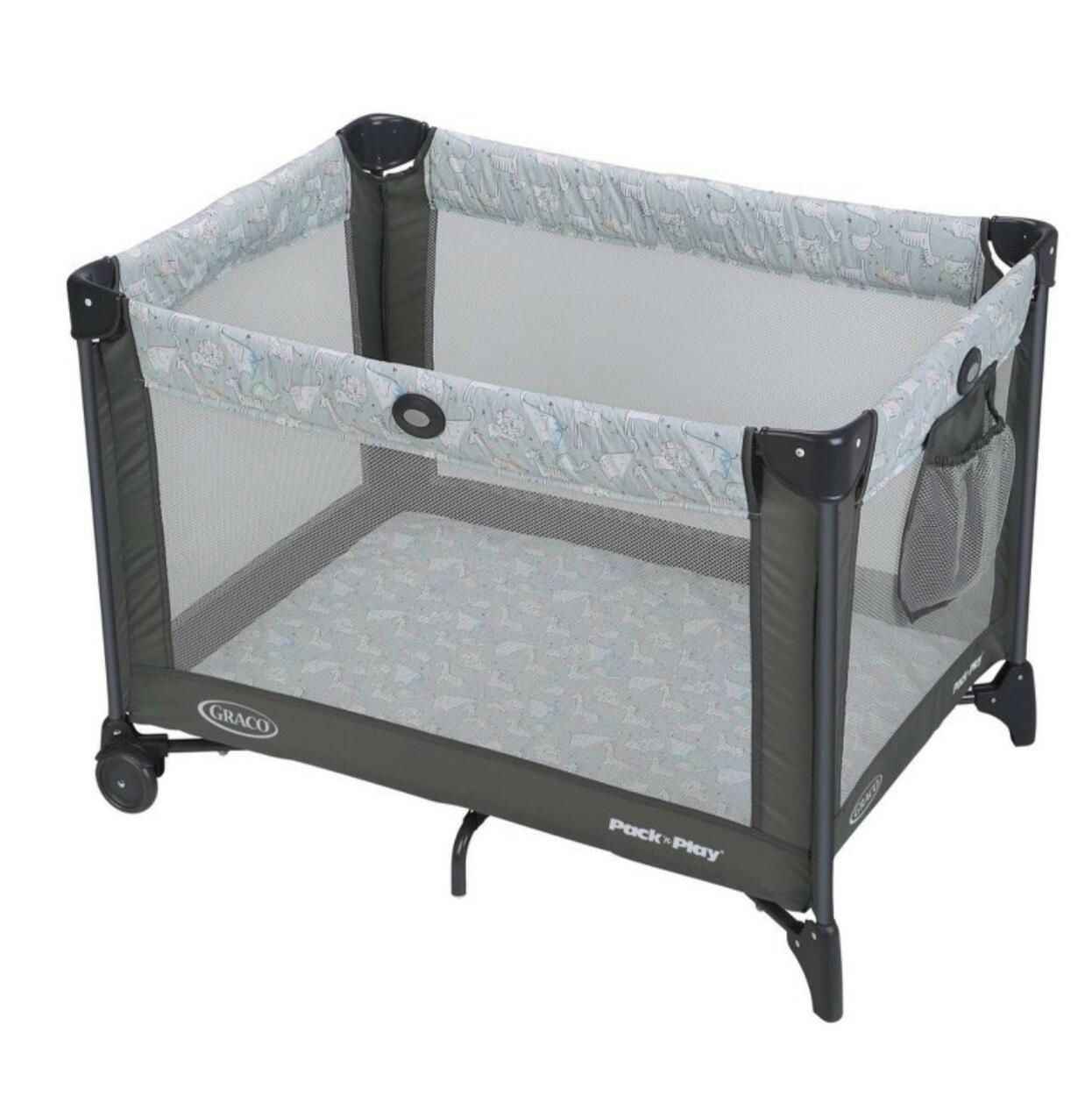 Un parc pour enfants portable, muni de roulettes, portant les marques « Pack 'n Play » et « GRACO », et doté d’un dessus en tissu à mailles et d’un fond solide.