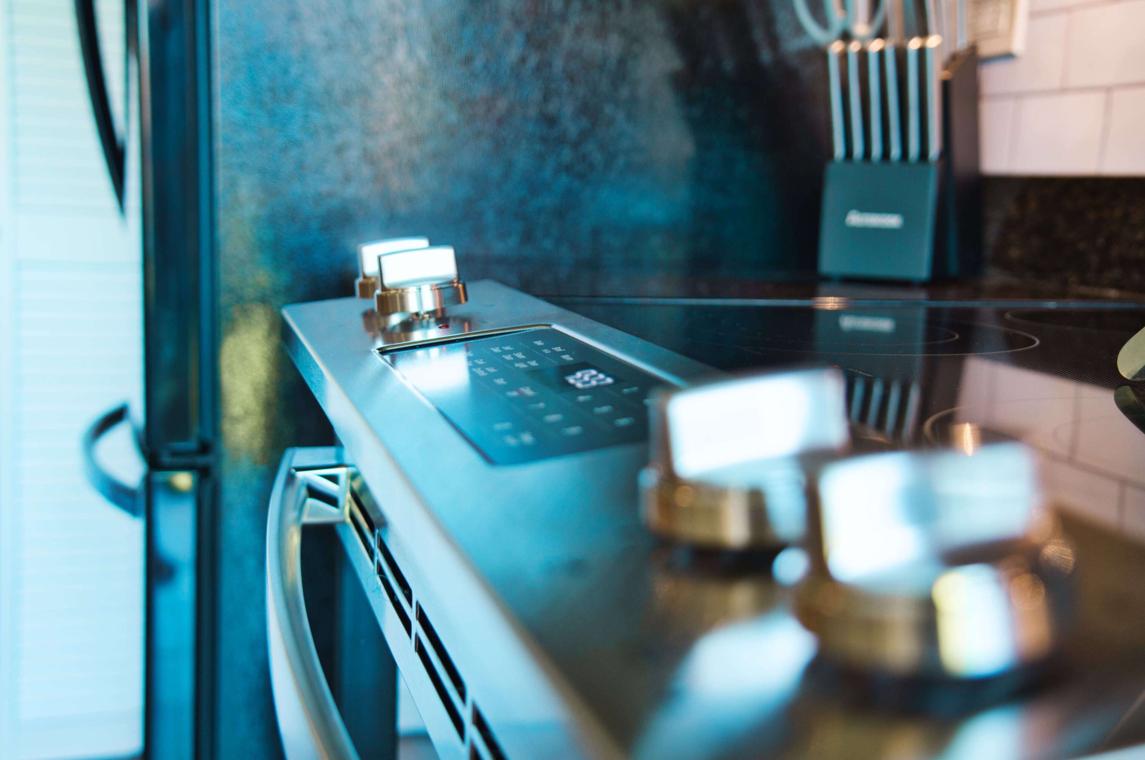 Une cuisine équipée d’une plaque de cuisson à induction moderne et d’un four encastré.