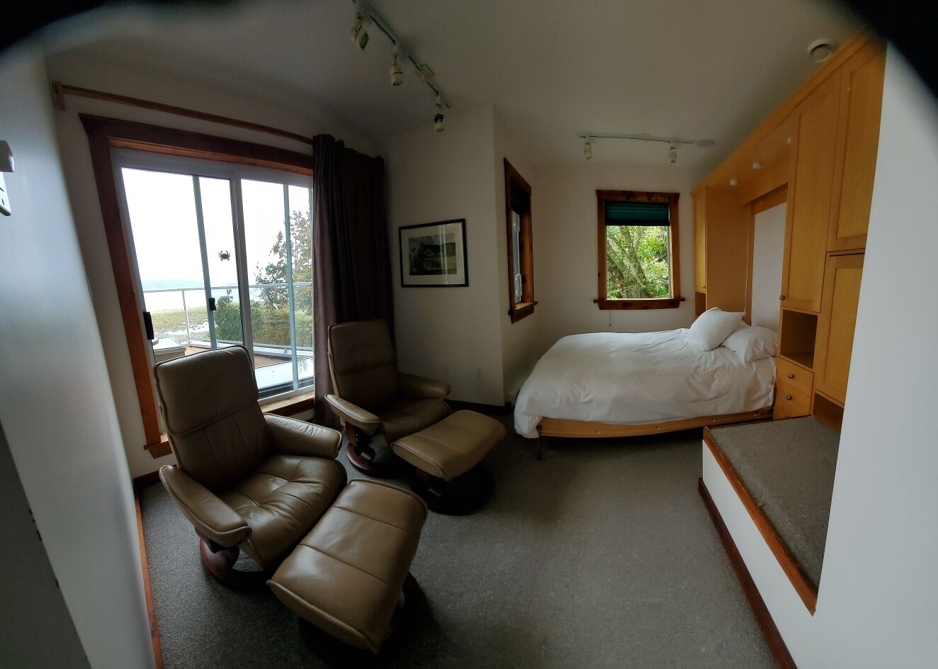 Une chambre d’hôtel avec un lit, une chaise, une petite table et une fenêtre.
