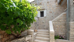 A stone staircase leading up to a building with a small window. - 3 bedroom cozy home in Povlja (Povlja)