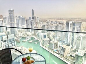 A high-rise building with a view of a marina and cityscape.