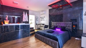 A modern bedroom with a large bed, a desk, and a seating area. - Awesome home in Catania with sauna (Catania)