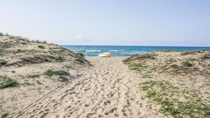 A sandy beach path leading to the ocean with a boat on the sand. - Awesome home in Catania with sauna (Catania)