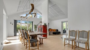 Un vaste espace de vie comprenant une table à manger en bois, des chaises et un canapé.