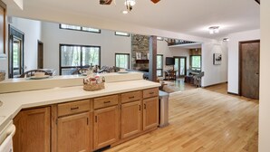 Une cuisine spacieuse avec des meubles en bois, un grand îlot central et un lustre moderne.