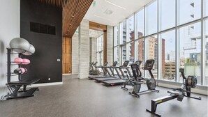 Une salle de sport équipée de tapis de course, de vélos d’appartement et d’appareils de musculation.