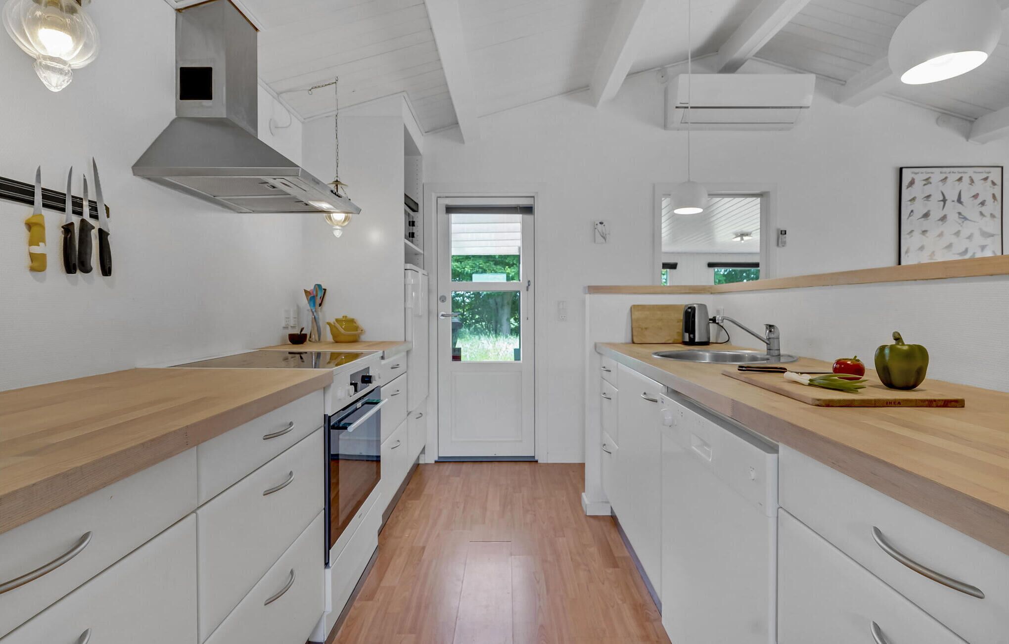 Eine moderne Küche mit weißen Schränken, Holz Arbeitsplatten und einer zentralen Kochinsel.