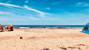 A beach with a tent labeled "LL Bean" and a few people in the distance. - Renovated family cottage; walk to amazing beach, short drive to golf & town (Sea View)