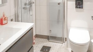 A bathroom with a shower, toilet, and sink.
