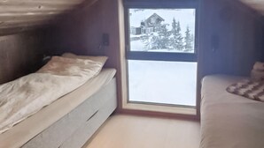 A small, cozy room with a single bed and a window.