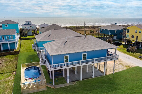 A coastal residential area with multiple houses, a swimming pool, and a view of the ocean.