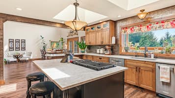 A spacious kitchen with a large island, wooden cabinets, and a view of the outdoors.