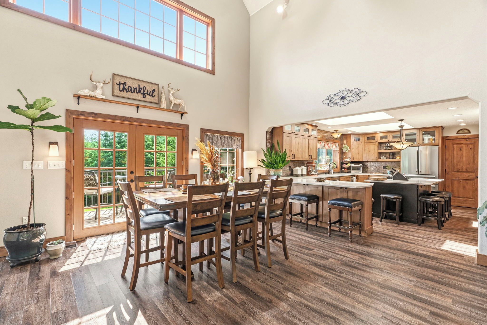 A spacious kitchen with wooden cabinets, a large island, and a dining area with a wooden table and chairs.