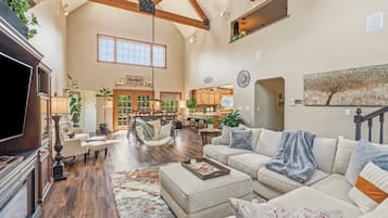 A spacious living room with a fireplace, a dining area, and a kitchen.