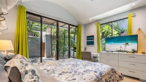 Un dormitorio con una cama, un escritorio y una televisión.
