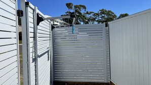 A gated entrance with a metal gate and a blue hanging object. - Two bedroom villa with private courtyard, a short walk to Manyana Beach. (Manyana)
