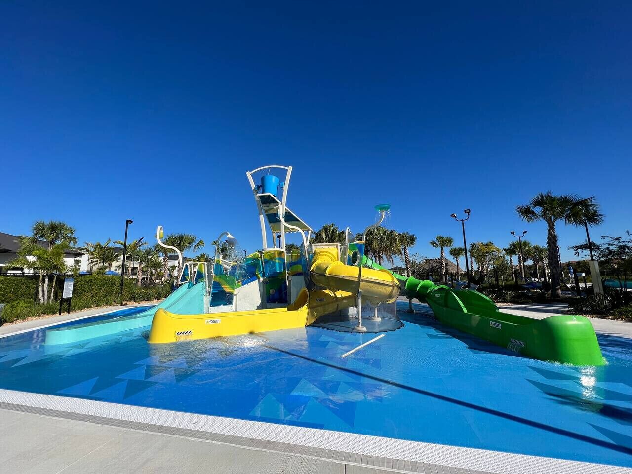 A water park with a large pool, slides, and a play structure.