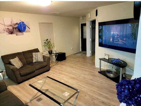 Relax in this stylish living room with a flat-screen TV, comfortable sofa, and a coffee table.