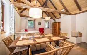 A dining area with a wooden table, wicker chairs, and a red chair. - Kellerstoeckl in Strem (Strem)