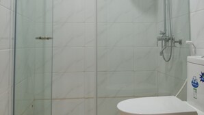 A glass-enclosed shower stall with a handheld showerhead and a wall-mounted faucet. - Meaco Royal Hotel- Lucena (Lucena)