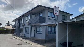 Un immeuble de deux étages sur lequel on peut lire une enseigne indiquant « Stanley Apartments 17A ».