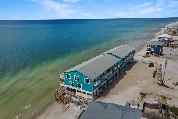 Un edificio frente al mar con varios balcones que dan a la playa y al océano.