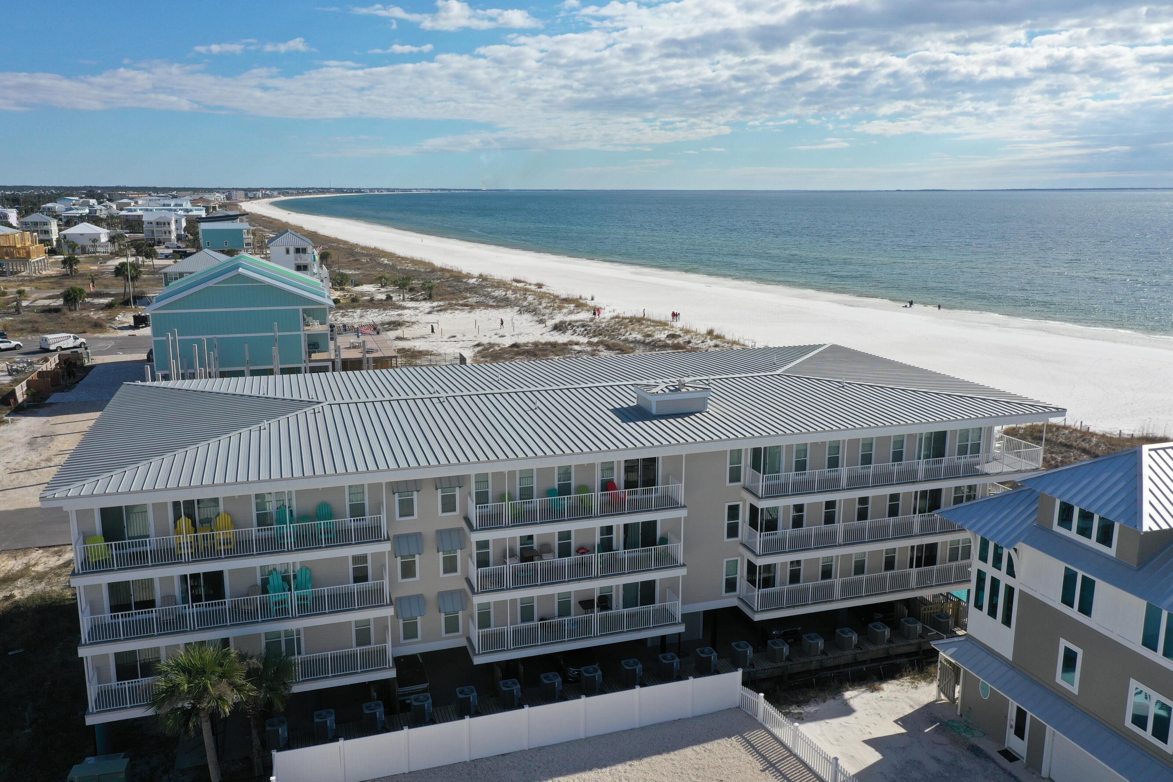 Un hotel de varios pisos con balcones que dan a una playa.