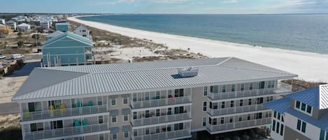 Un hotel de varios pisos con balcones que dan a una playa.