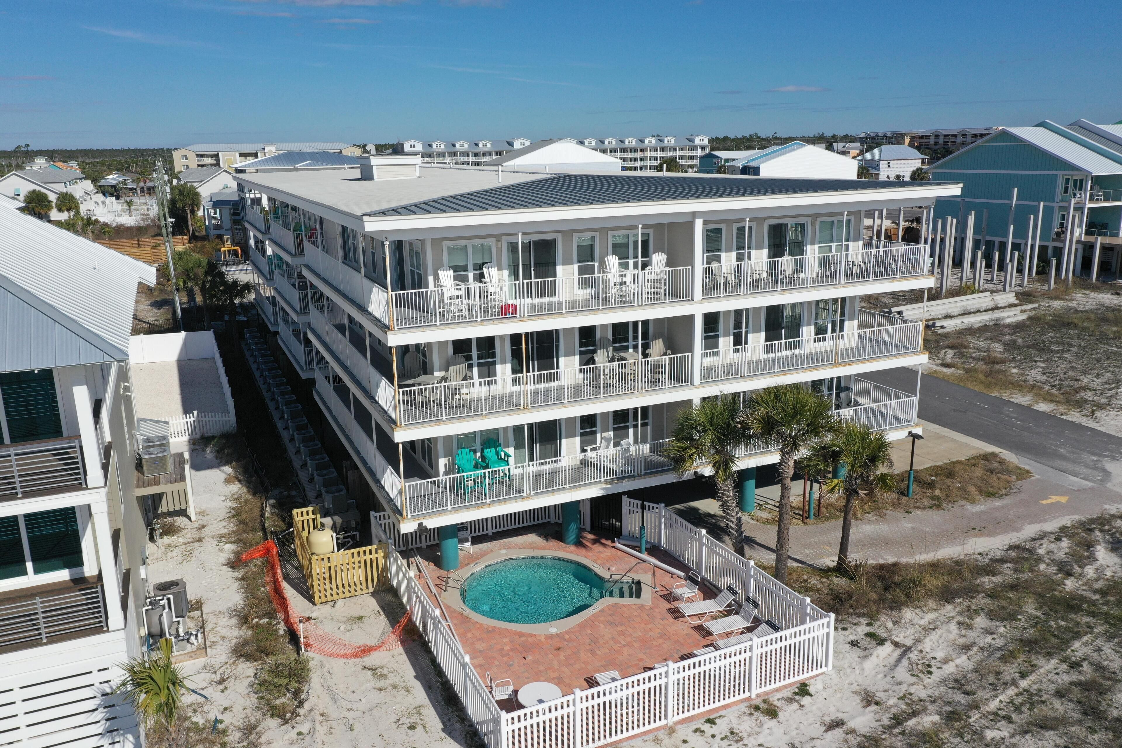 Un hôtel à plusieurs étages doté d’une piscine sur le toit, d’un espace extérieur aménagé et offrant une vue sur la plage.