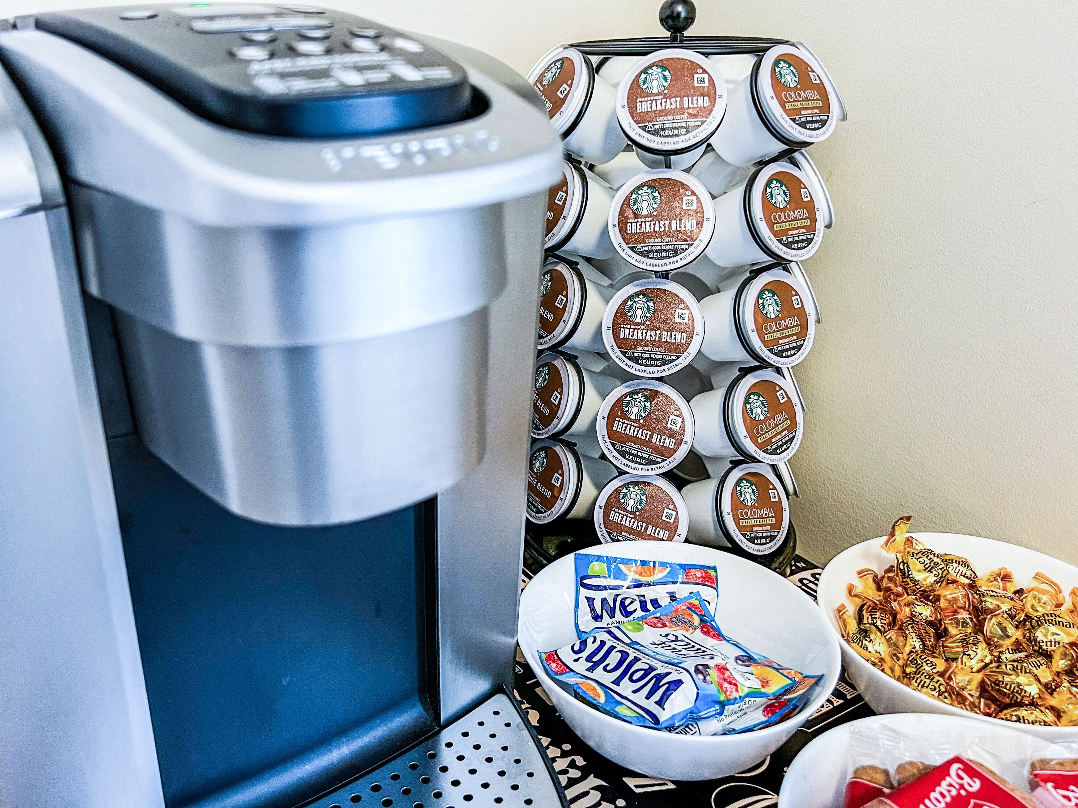 Une machine à café, un distributeur de capsules de café Starbucks et un bol de collations.