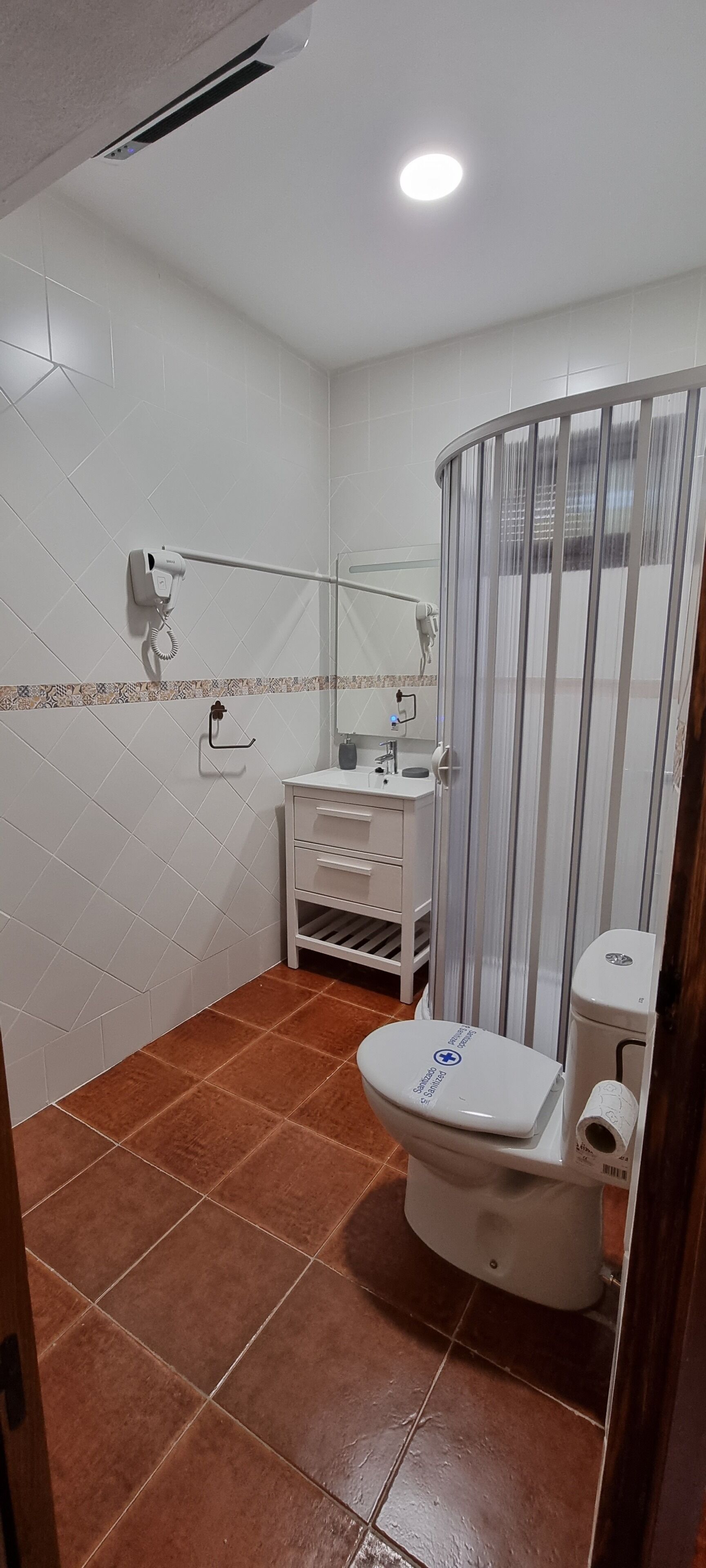 Une salle de bain équipée de toilettes, d’un lavabo et d’un espace douche.