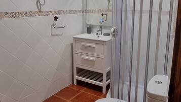Une salle de bain équipée de toilettes, d’un lavabo et d’un espace douche.
