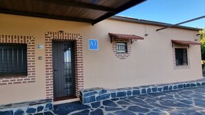 Un edificio con fachada color crema, puerta negra y un letrero azul que indica un apartamento.