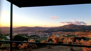 Una vista panorámica de un valle con un pueblo y montañas al fondo.
