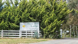 A sign for Daisy Hill Lodge with a contact number.