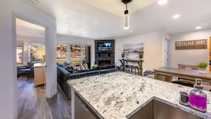 A modern kitchen with a granite countertop, a fireplace, and a dining area. - Total Renovation 300' from Chili Express (Angel Fire)